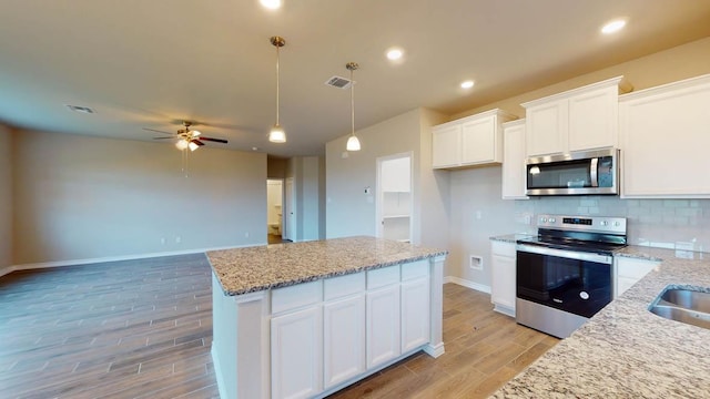 kitchen featuring a ceiling fan, appliances with stainless steel finishes, light wood finished floors, and visible vents
