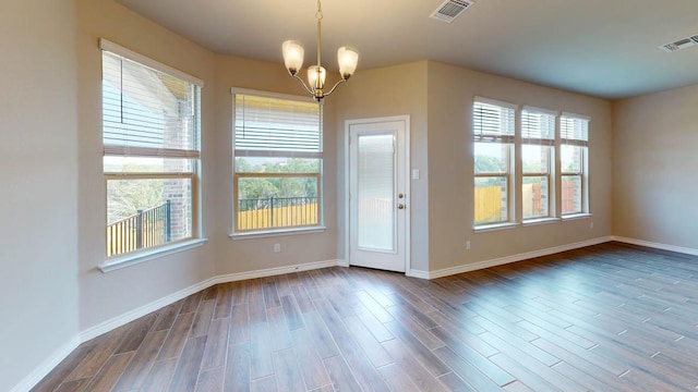 entryway with dark wood-style floors, a chandelier, visible vents, and plenty of natural light