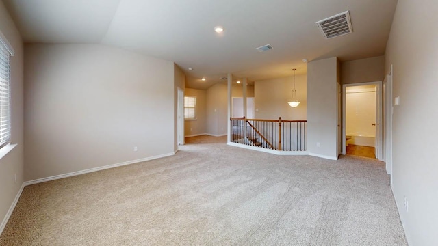 spare room with lofted ceiling, visible vents, and carpet