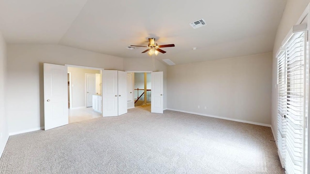 unfurnished bedroom featuring baseboards, visible vents, light colored carpet, and ceiling fan