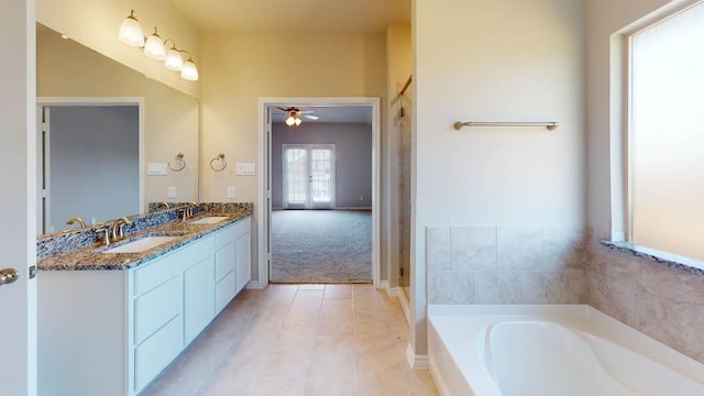 full bathroom featuring a garden tub, tile patterned flooring, ceiling fan, and a sink