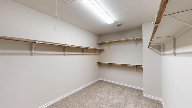 spacious closet featuring attic access, visible vents, and carpet floors