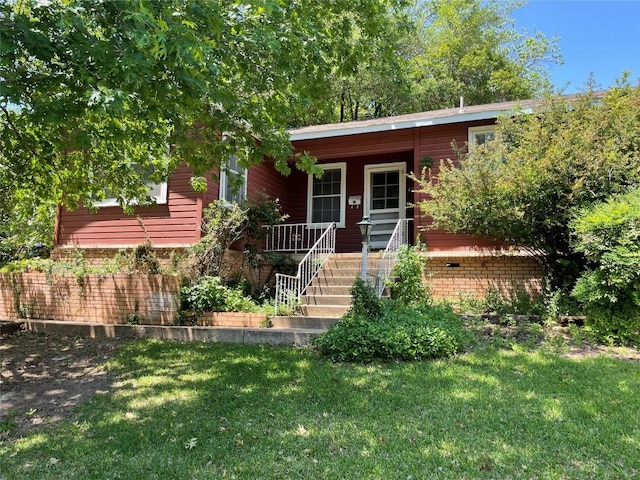 view of front of property with a front lawn, brick siding, and covered porch