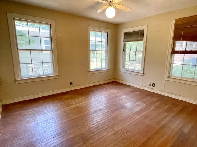 unfurnished room with hardwood / wood-style flooring, baseboards, and a ceiling fan