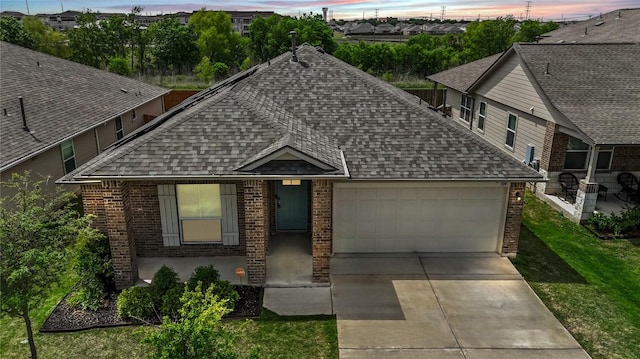 109 Rochester Ln, Hutto, TX 78634 - view of front of house with roof with shingles, brick siding, an attached garage, and concrete driveway