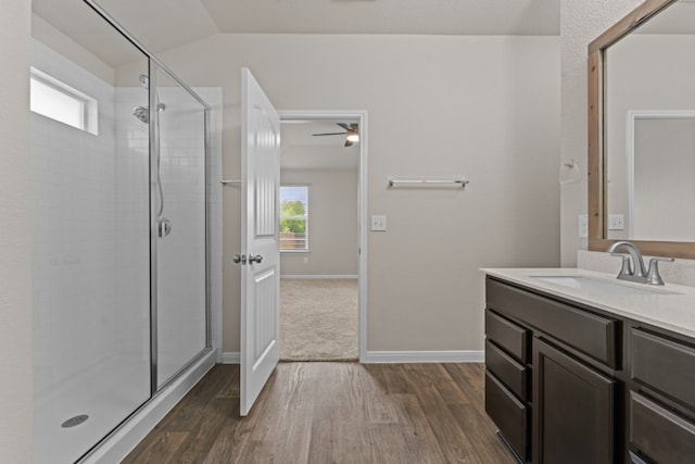 109 Rochester Ln, Hutto, TX 78634 - full bathroom with a stall shower, wood finished floors, vanity, lofted ceiling, and baseboards