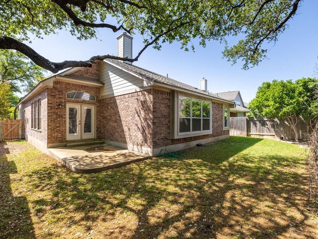 2101 Burnie Bishop Pl, Cedar Park, TX 78613 - back of house featuring french doors, a chimney, brick siding, and a fenced backyard