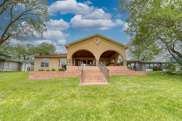3320 River Oaks Dr, Kingsland, TX 78639 - rear view of property with a lawn, stairway, and stucco siding