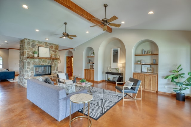 3320 River Oaks Dr, Kingsland, TX 78639 - living room with built in shelves, concrete flooring, a stone fireplace, a ceiling fan, and arched walkways