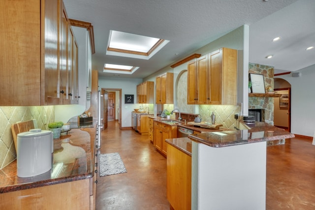 3320 River Oaks Dr, Kingsland, TX 78639 - kitchen featuring a peninsula, tasteful backsplash, concrete floors, a fireplace, and dishwasher