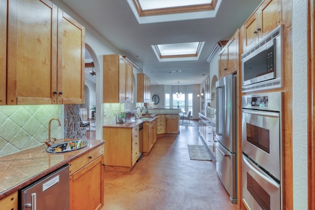 3320 River Oaks Dr, Kingsland, TX 78639 - kitchen featuring stainless steel appliances, backsplash, concrete flooring, a peninsula, and light countertops