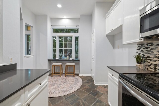 2918 N 620th Rd Unit O282, Austin, TX 78734 - kitchen with stainless steel appliances, dark countertops, backsplash, stone tile flooring, and baseboards