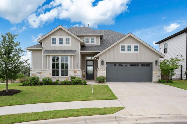 craftsman-style house with board and batten siding, a shingled roof, stone siding, and concrete driveway
