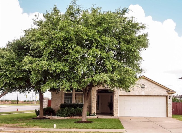 17300 Zola Ln, Round Rock, TX 78664 - obstructed view of property featuring concrete driveway, an attached garage, stone siding, and a front lawn