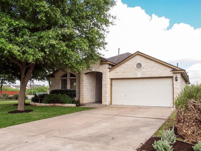 17300 Zola Ln, Round Rock, TX 78664 - view of front of property featuring stone siding, a garage, driveway, and a front yard