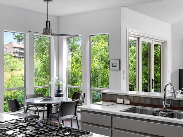 interior space featuring light countertops, pendant lighting, gray cabinetry, and a sink