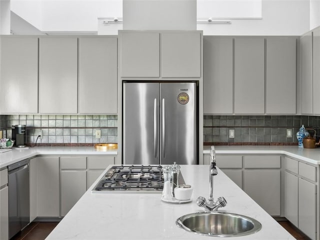 7115 Las Ventanas Dr, Austin, TX 78731 - kitchen with stainless steel appliances, decorative backsplash, gray cabinetry, and light stone countertops
