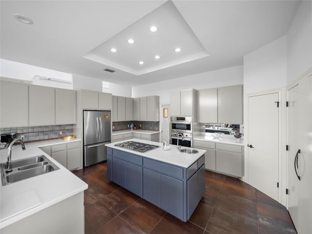 7115 Las Ventanas Dr, Austin, TX 78731 - kitchen featuring stainless steel appliances, a kitchen island, recessed lighting, a tray ceiling, and tasteful backsplash