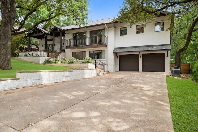 4828 Timberline Dr, Austin, TX 78746 - view of front of home with a standing seam roof, a metal roof, stucco siding, a garage, and a balcony