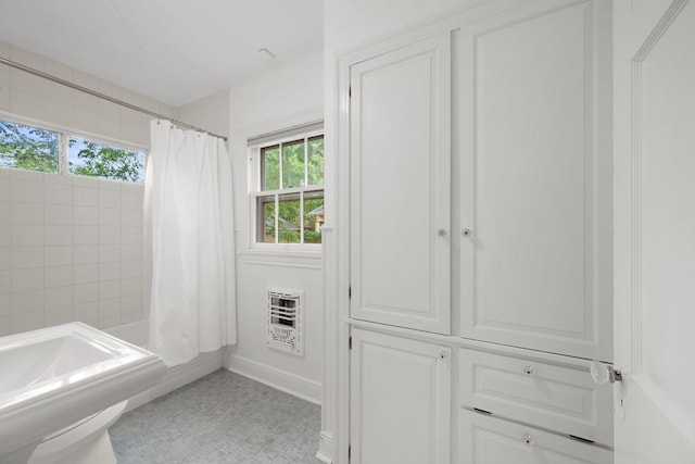 full bath featuring heating unit, baseboards, and shower / bath combo with shower curtain