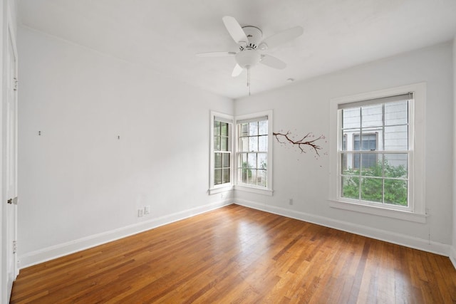 unfurnished room featuring plenty of natural light, light wood finished floors, baseboards, and a ceiling fan