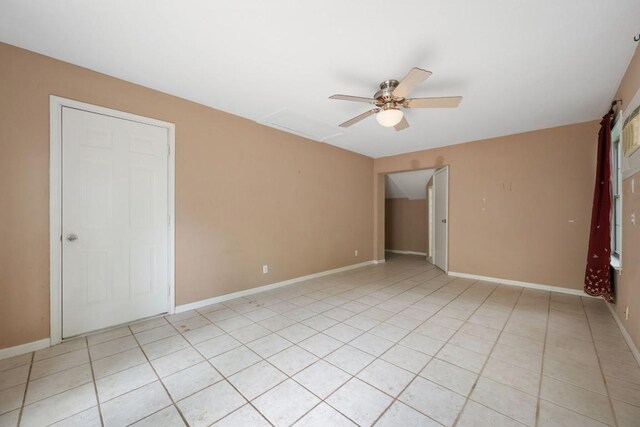 unfurnished room with a ceiling fan, baseboards, and light tile patterned flooring