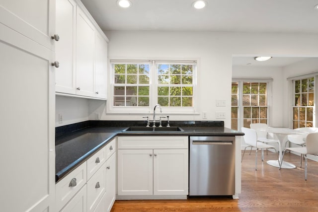kitchen with recessed lighting, stainless steel dishwasher, a sink, light wood-style floors, and white cabinetry