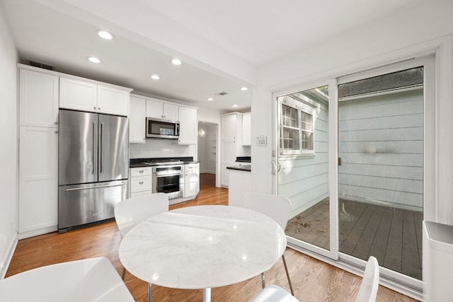 kitchen featuring stainless steel appliances, light wood-style flooring, recessed lighting, and white cabinetry