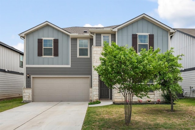 713 Hummingbird Ln, Leander, TX 78641 - view of front of home with board and batten siding, an attached garage, stone siding, concrete driveway, and a front lawn