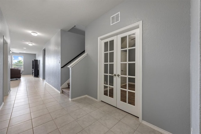 713 Hummingbird Ln, Leander, TX 78641 - hall featuring french doors, stairway, and light tile patterned flooring