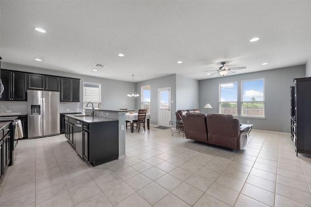 713 Hummingbird Ln, Leander, TX 78641 - kitchen with stainless steel appliances, healthy amount of natural light, ceiling fan, dark cabinetry, and recessed lighting