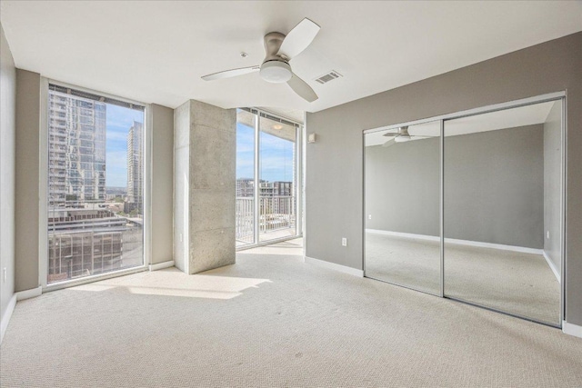 360 Nueces St Unit 1208, Austin, TX 78701 - unfurnished bedroom featuring access to exterior, carpet floors, multiple windows, a closet, and floor to ceiling windows