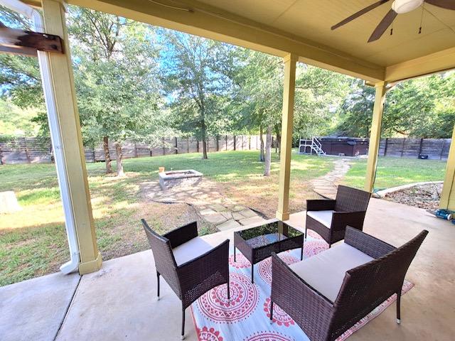 192 W Kaanapali Ln, Bastrop, TX 78602 - fenced backyard featuring ceiling fan, a patio, and an outdoor living space with a fire pit