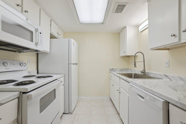 kitchen featuring visible vents, white appliances, light countertops, white cabinets, and a sink