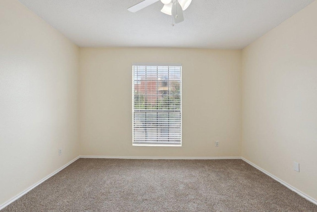 carpeted spare room with baseboards and ceiling fan