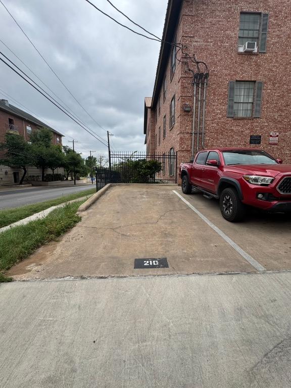 uncovered parking lot with fence and cooling unit