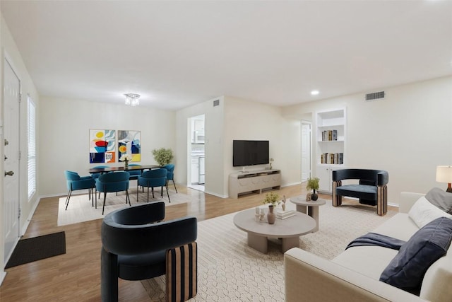 living room with visible vents, a healthy amount of sunlight, and light wood finished floors