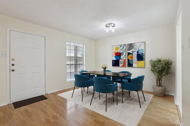 dining area featuring light wood-type flooring and baseboards