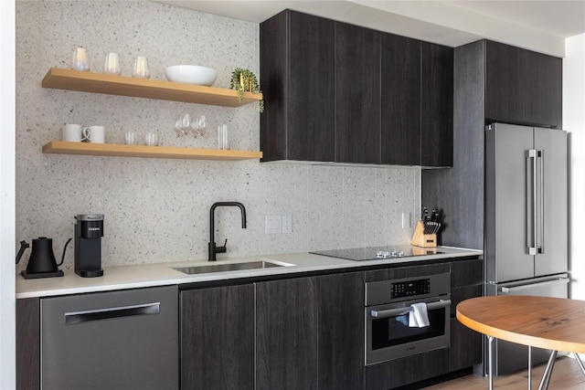 kitchen featuring a sink, stainless steel appliances, open shelves, light countertops, and modern cabinets