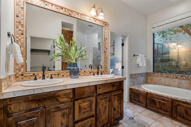13606 Montview Dr, Austin, TX 78732 - bathroom featuring double vanity, tile patterned flooring, a bath, and decorative backsplash