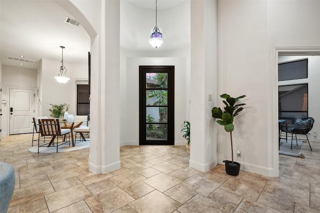 13606 Montview Dr, Austin, TX 78732 - foyer entrance featuring baseboards, arched walkways, and stone finish floors