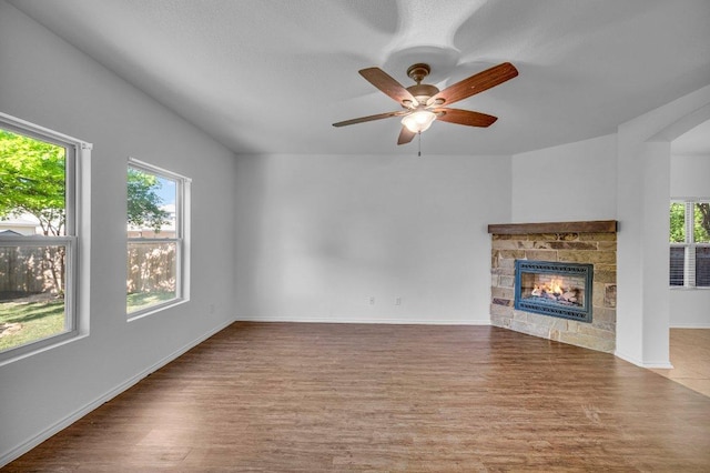 unfurnished living room with plenty of natural light, wood finished floors, and a fireplace