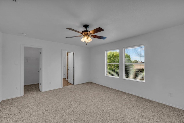 unfurnished room featuring ceiling fan, light colored carpet, and baseboards
