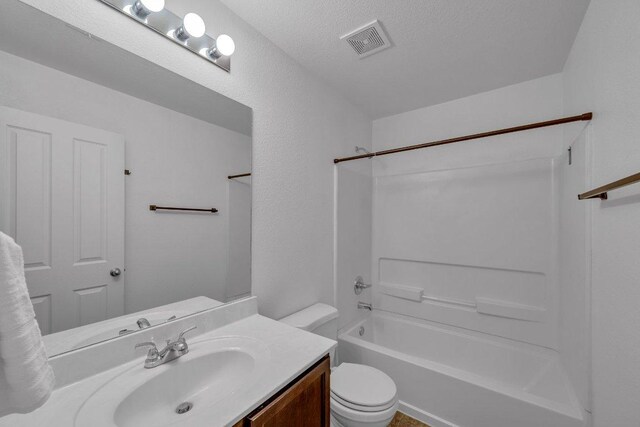 1013 Hondo Ln, Hutto, TX 78634 - bathroom with visible vents, vanity, toilet, a textured ceiling, and shower / washtub combination