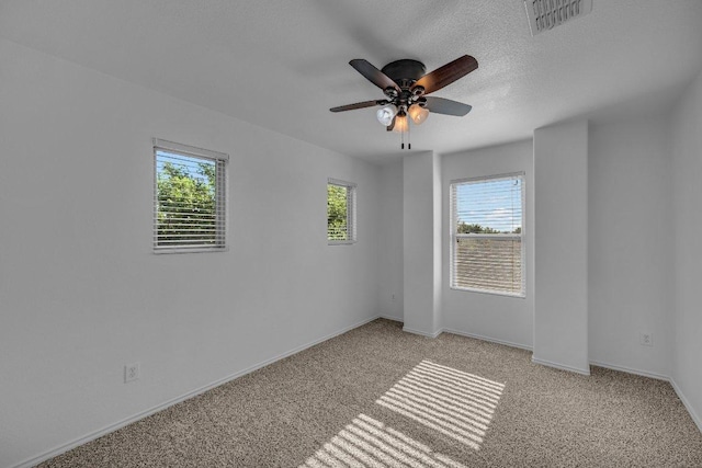 unfurnished room with baseboards, a ceiling fan, light colored carpet, and visible vents
