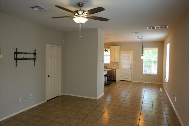 unfurnished room featuring visible vents, a ceiling fan, baseboards, and light tile patterned floors