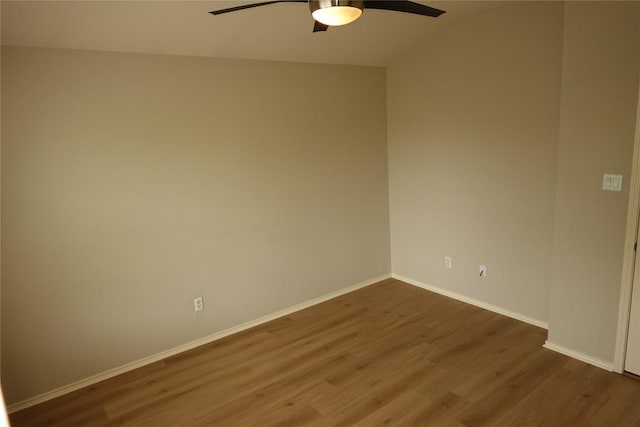 empty room with a ceiling fan, baseboards, and dark wood-style flooring
