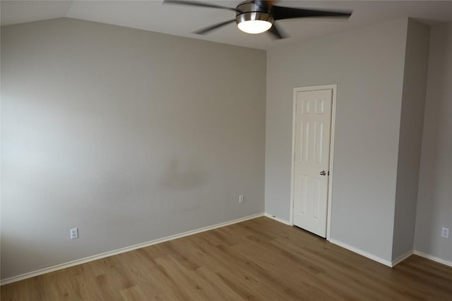 empty room with wood finished floors, a ceiling fan, and baseboards