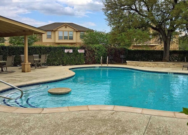 community pool featuring a patio area and a fenced backyard