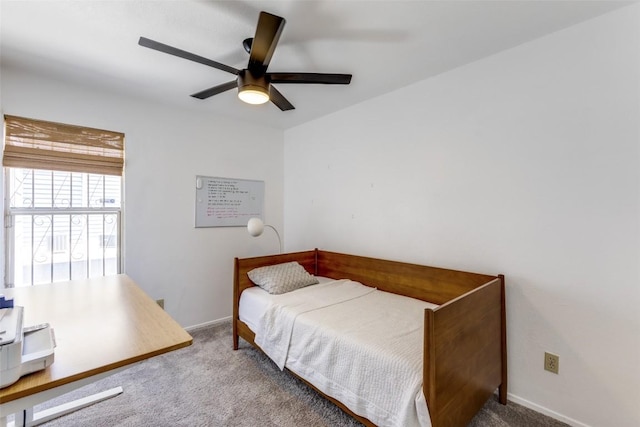 carpeted bedroom featuring baseboards and a ceiling fan